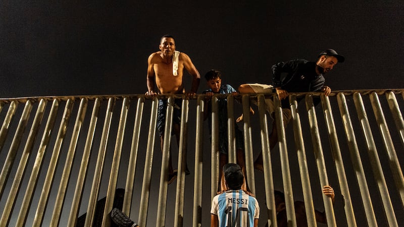 Migrantes tratan de cruzar la cerca que separa Marruecos del enclave español de Ceuta, en el...