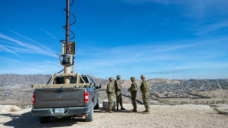 ARCHIVO Soldados miran el muro fronterizo cerca de un vehículo de vigilancia durante la...