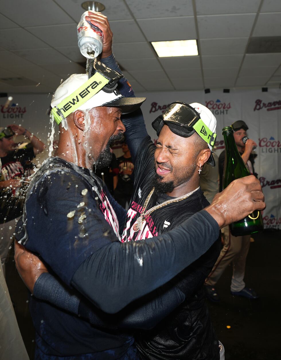 Ozzie Albies, derecha, de los Bravos de Atlanta, celebra en la casa club del equipo visitante...