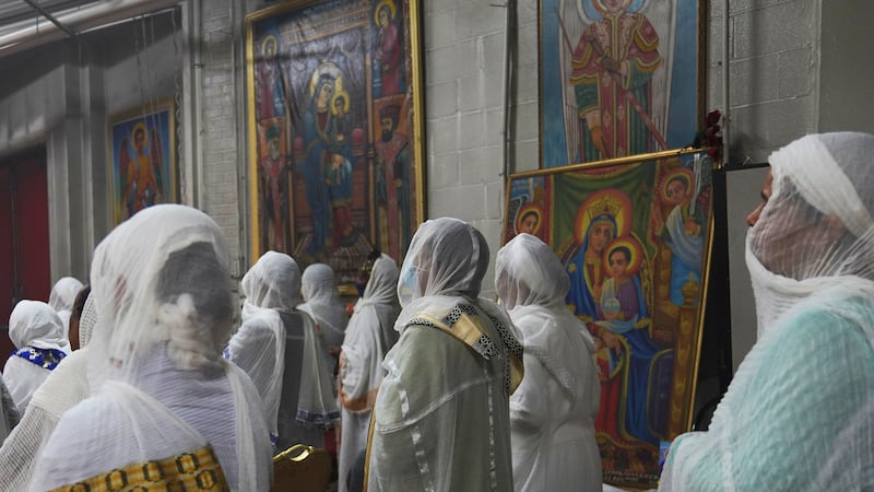 ARCHIVO - Las feligresas portan netela, una tela de algodón blanca similar a un pañuelo que...