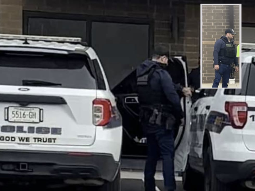 Policía federal con distintivo en su chaleco bajando de una patrulla de policía de Portland y...