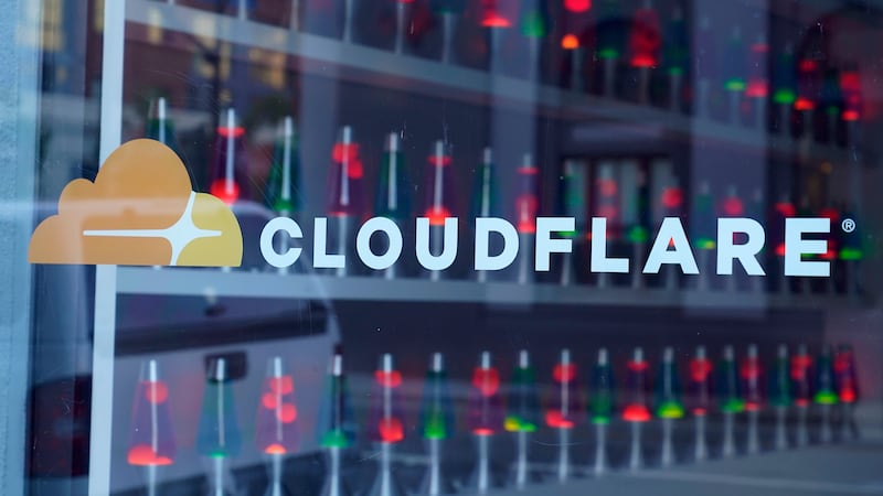FILE - Lava lamps are seen through a lobby window at the headquarters of Cloudflare in San...