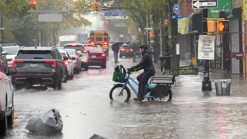 Un ciclista atraviesa una inundación durante una tormenta en Nueva York, el jueves 30 de...
