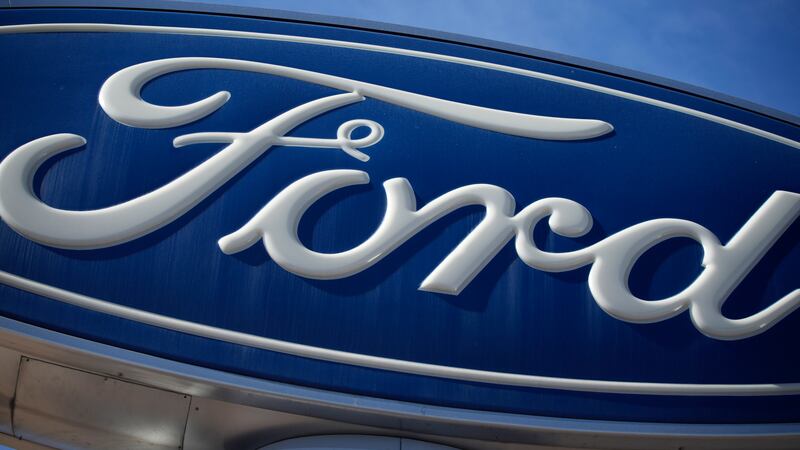 FILE - The Ford company logo is seen, Oct. 24, 2021, on a sign at a Ford dealership in...